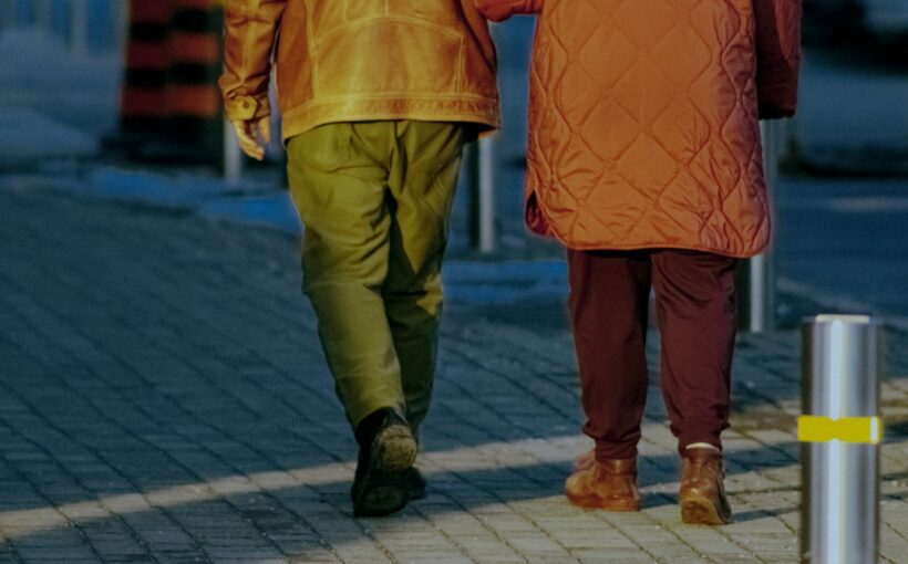 Couple de retraités marchant ensemble en extérieur, illustrant la retraite